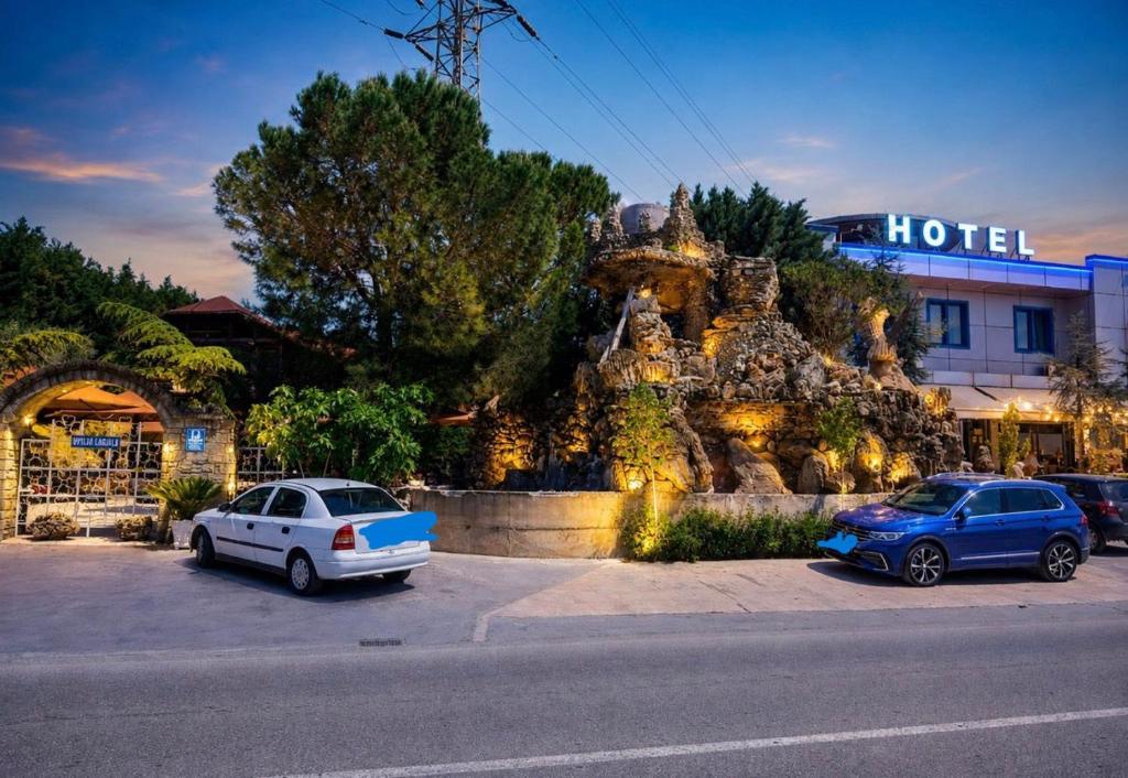 two cars parked in a parking lot in front of a hotel at BAR RESTORANT HOTEL ALPET Elbasan in Elbasan