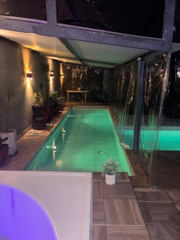 a swimming pool at night with a green pool at a termas voy in Termas de Río Hondo
