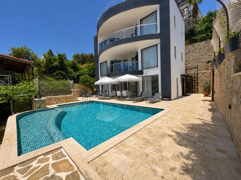 a swimming pool in front of a house at Villa Yagmur in Kalkan