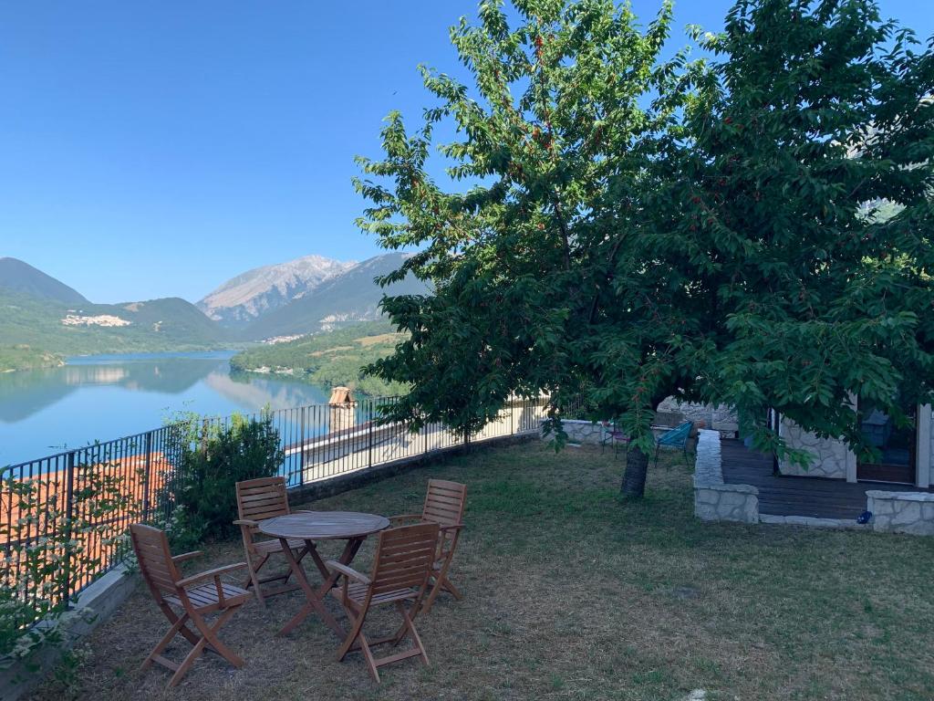 a table and chairs next to a tree and a lake at Il giardino di Lallo in Barrea