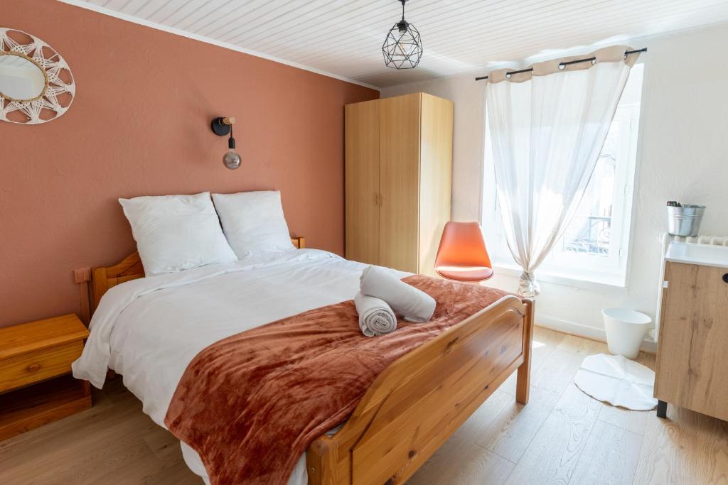 ein Schlafzimmer mit einem großen Bett und einem Fenster in der Unterkunft Le Zigzag in Retournac