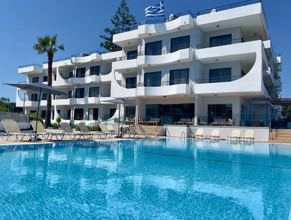 a hotel with a swimming pool in front of a building at Ivory Serenity in Theologos