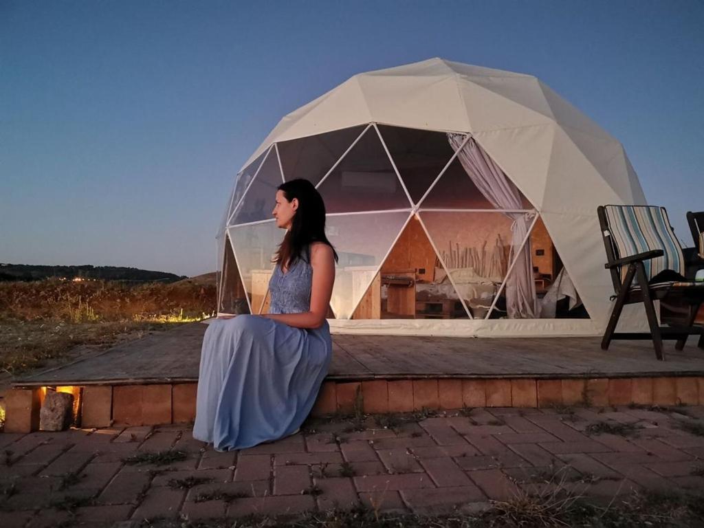 a woman sitting on a wall in front of a tent at Magic rum hussen Luxury in Wadi Rum