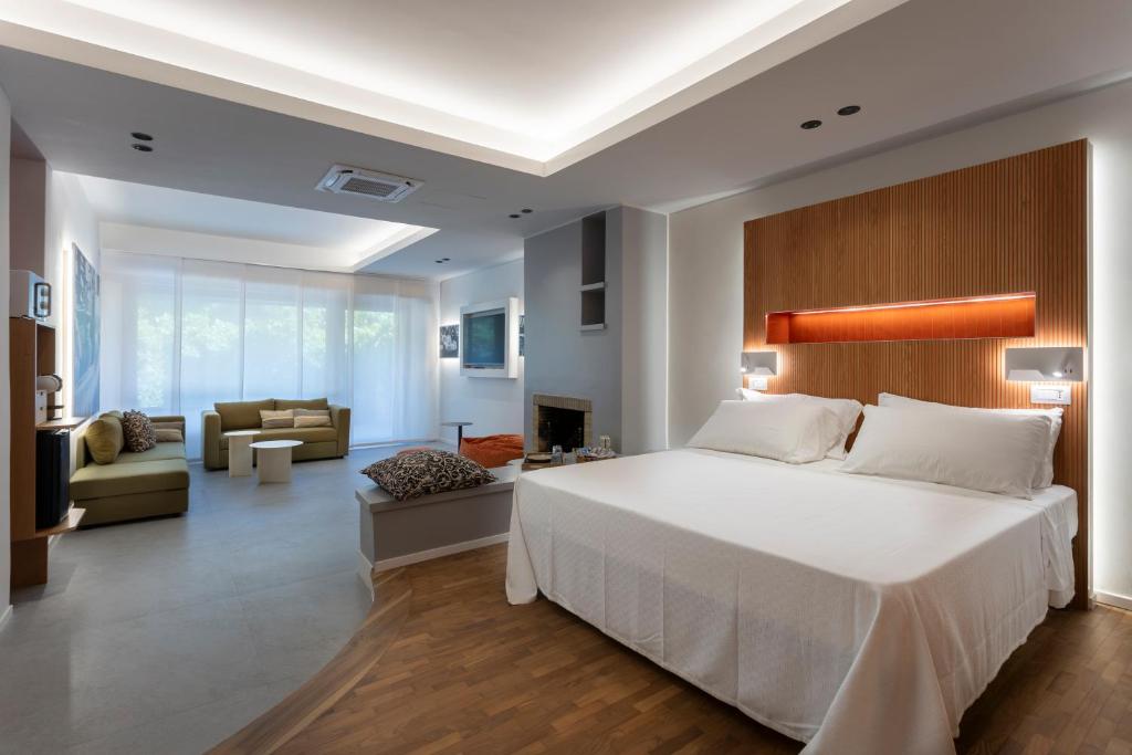 a bedroom with a large bed and a living room at Velino Business Suite in Avezzano