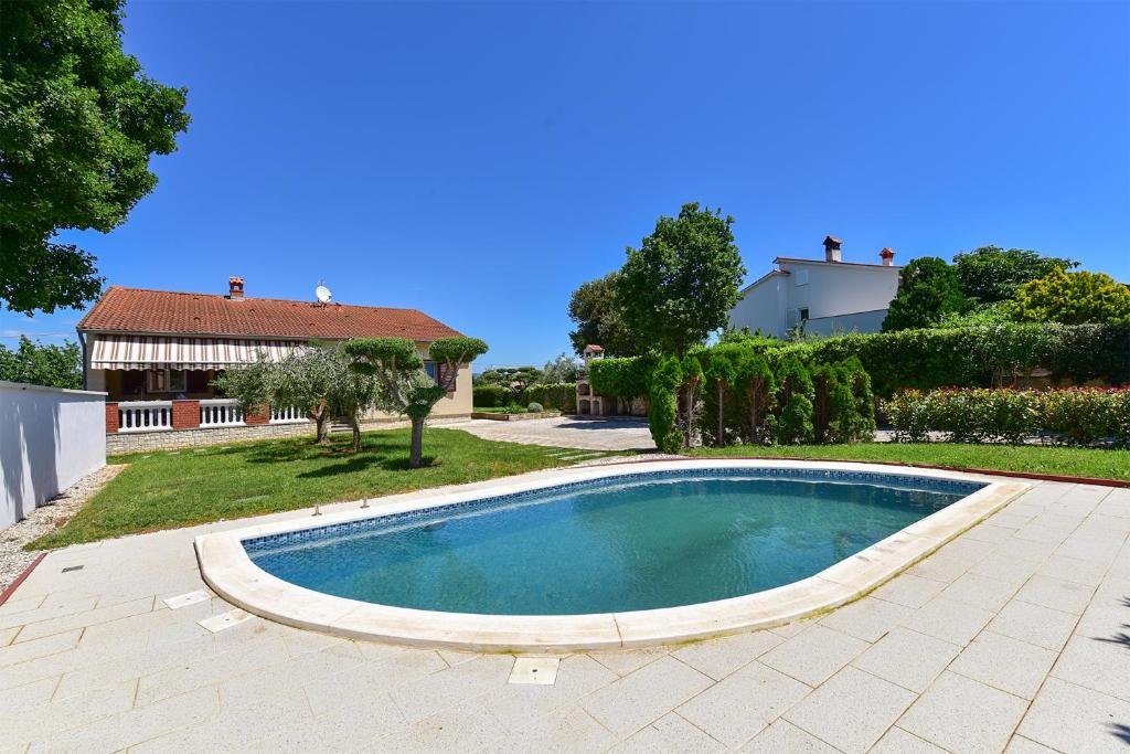 a swimming pool in a yard next to a house at House Pavicini 333 in Pavicini