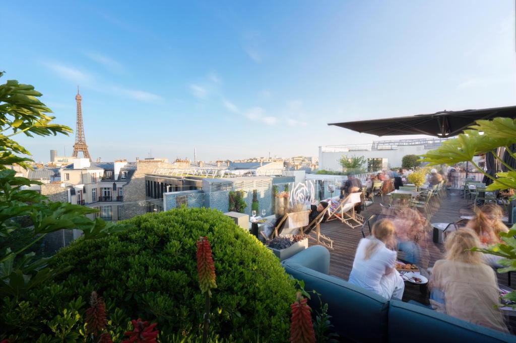 a group of people sitting on a rooftop with the eiffel tower at Canopy By Hilton Paris Eiffel Tower in Paris
