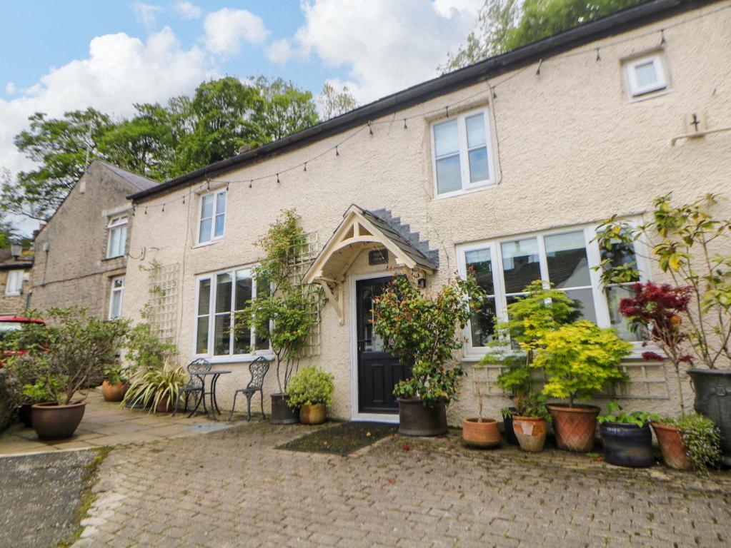 a brick house with potted plants in front of it at Bargate Cottage in Castleton