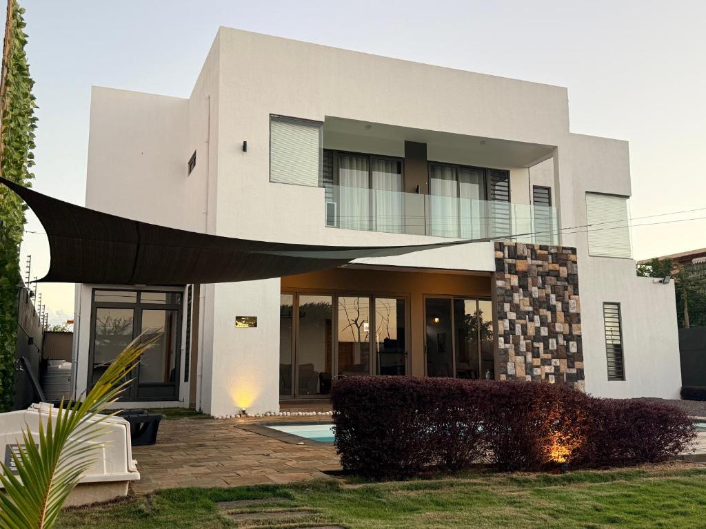 a large white house with a black object at VLAP Residence in Baie du Tombeau