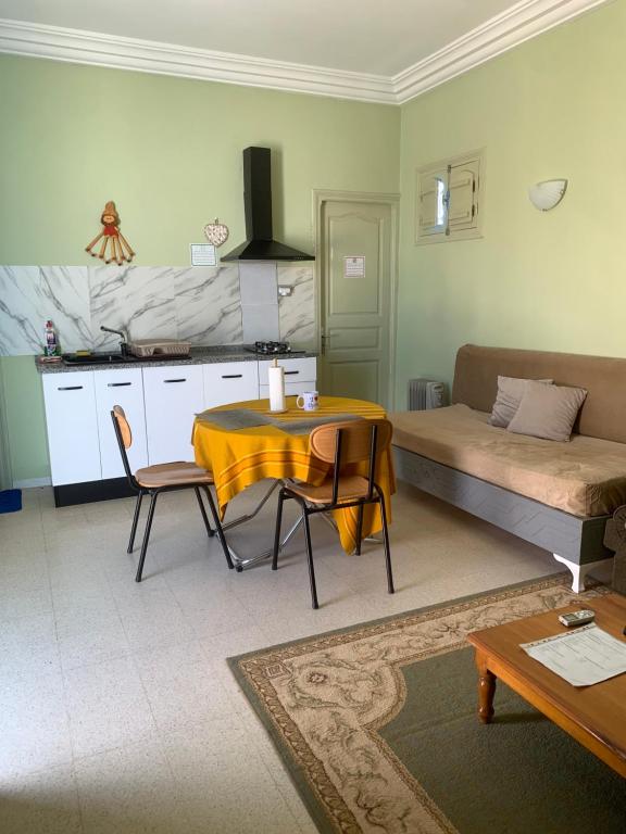 a living room with a table and a bed at Le Typique Djerbien in Houmt Souk
