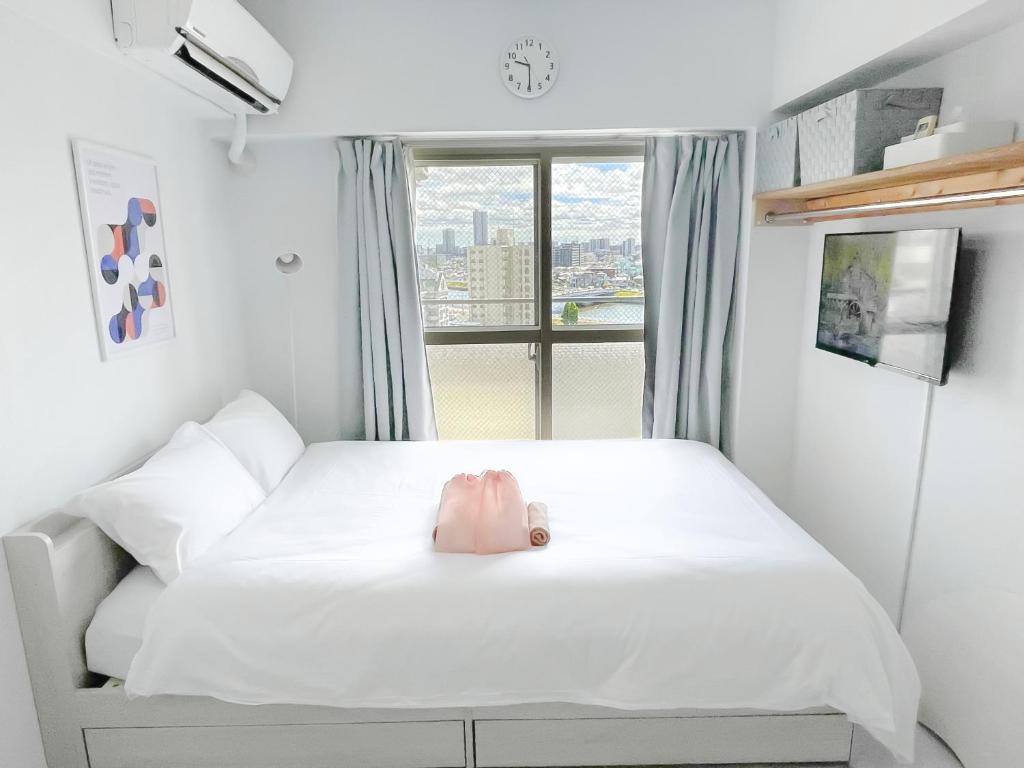 a small bedroom with a white bed and a window at Kameari 1110 - 11F Newly Renovated High Floor City View 2min to Mall 5min to Station Disney Access in Tokyo