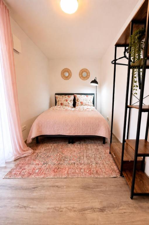 a bedroom with a bed with a pink bedspread at Stilvolles Apartment mit Balkon - zentrumsnah, self checkin in Augsburg