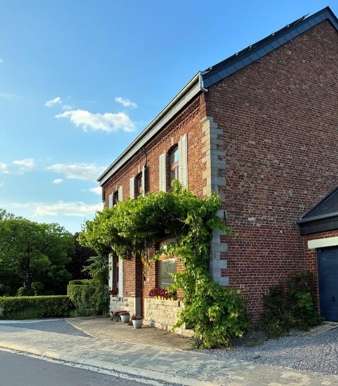 a brick building with ivy on the side of it at La Vigne - Han-sur-Lesse in Han-sur-Lesse