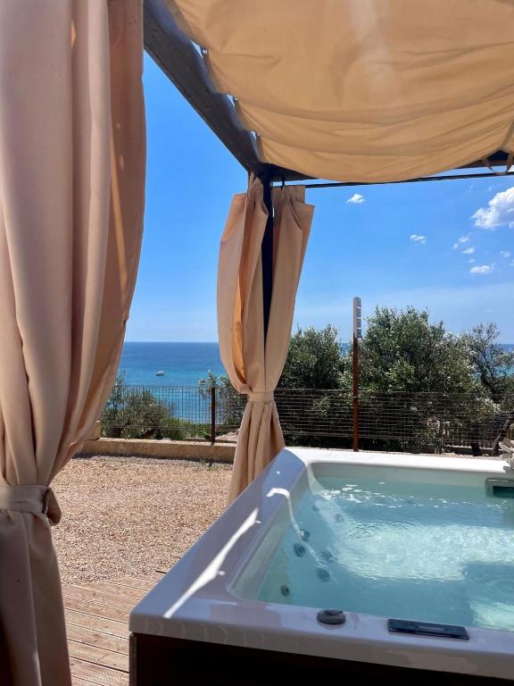 a jacuzzi tub with a view of the ocean at TRULLO VISTA MARE - Mini piscina riscaldata con idromassaggio in Marina San Gregorio
