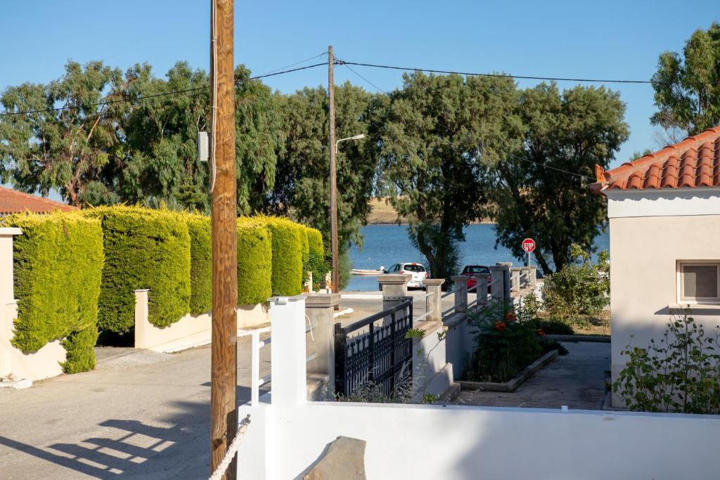 a house with a white fence and a view of the water at SpoonLand in Néa Koútali