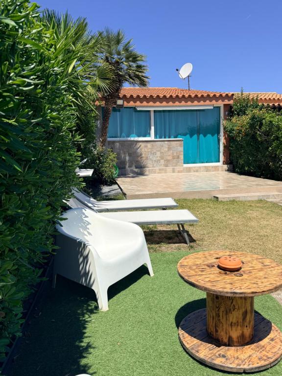 a garden with two benches and a table at Da Michele 2 in Costa Rei