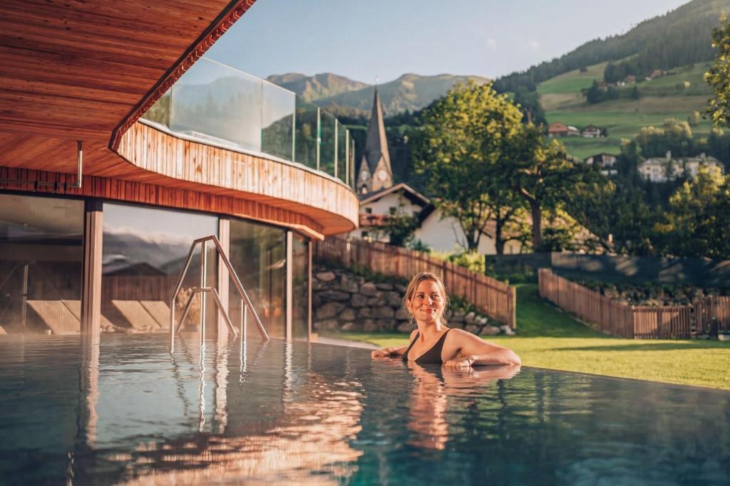 a woman in a swimming pool in a house at Naturhotel Outside in Matrei in Osttirol