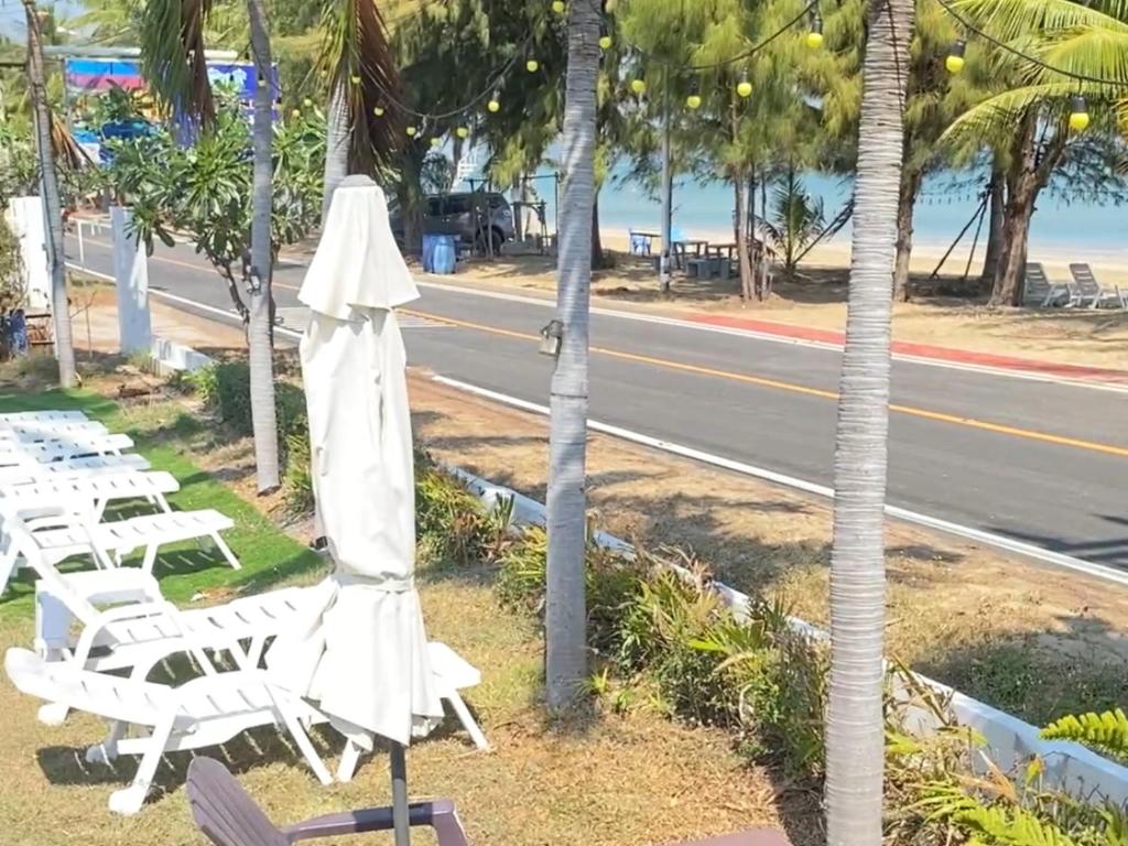 a group of chairs and umbrellas next to a street at Baan Golden Pool Villa in Sam Roi Yot
