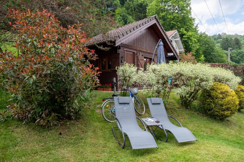 a group of chairs and a table and a house at Chalet Chez Corinne in Cornimont