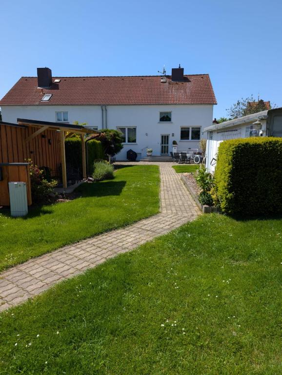 a house with a brick walkway in the yard at Ferienhaus "Fritz" mit 3 Schlafzimmern in Seenähe in Löbnitz