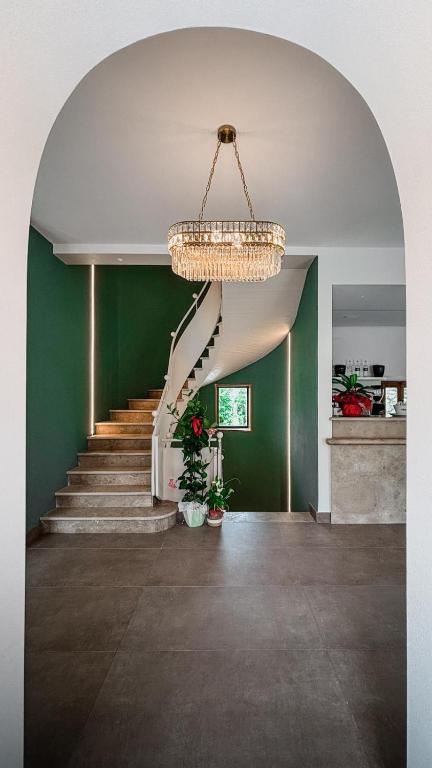 a staircase in a house with a chandelier at Hotel Sangallo in Monte San Savino
