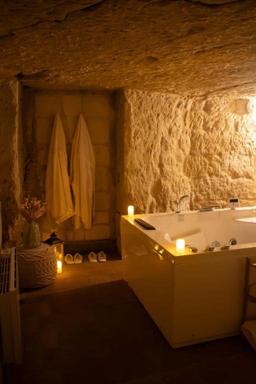 a bathroom with a tub and a sink with candles at Lantray Secrète in Les-Trois-Moutiers