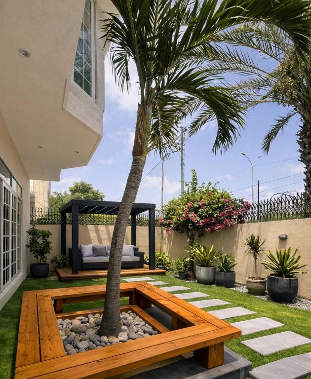 a garden with a bench and a palm tree at Sable d'Or Résidence by Star 'A' in Karachi