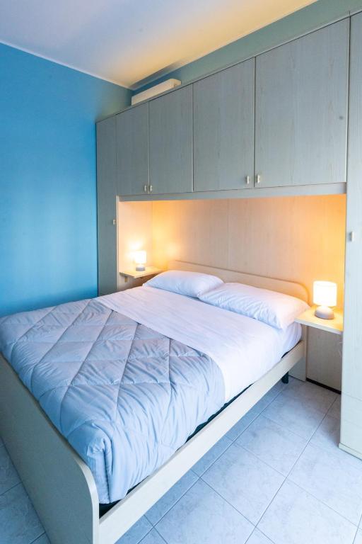 a bedroom with a large bed with blue walls and cabinets at Casa Gelsomina in Isola Bacucco