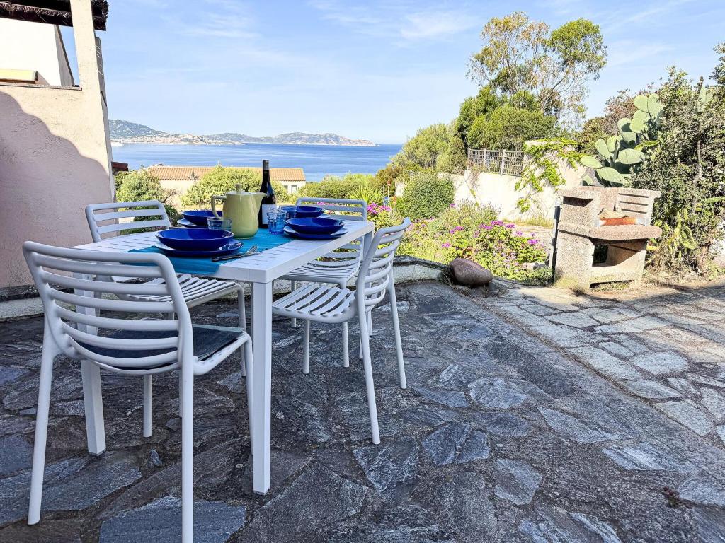 a white table and chairs with a view of the water at Ostrica in Lumio