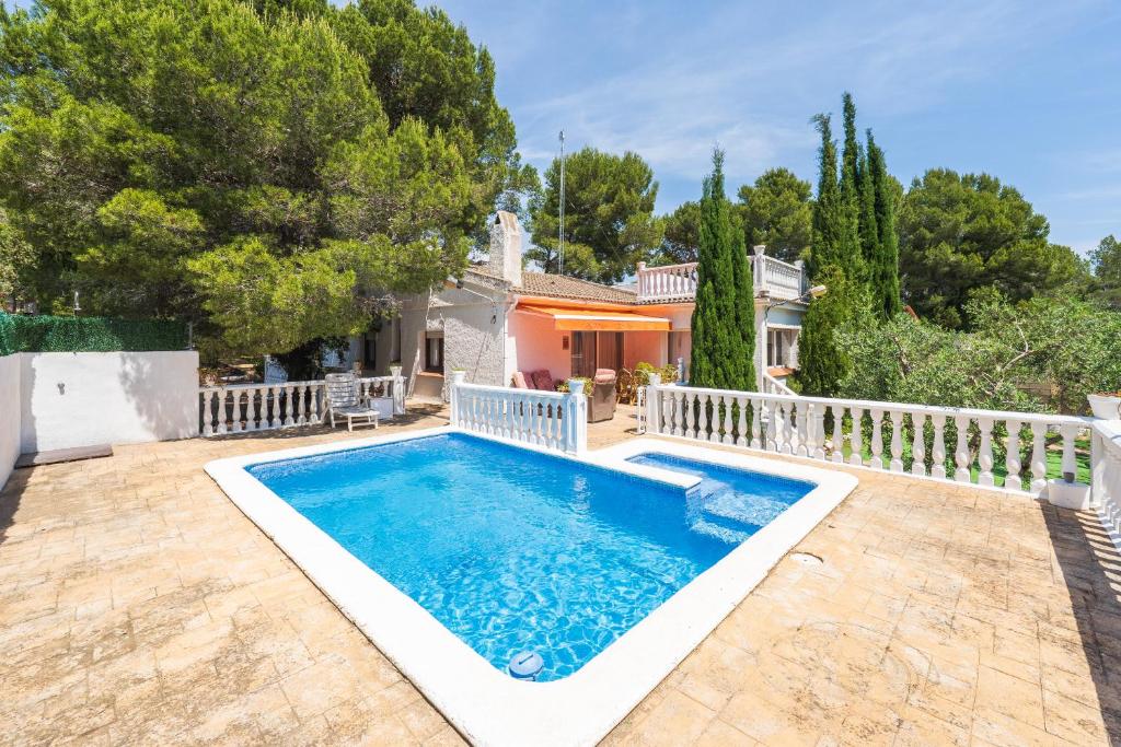 a villa with a swimming pool in front of a house at Hauzify I Casa Peralta in Les tres Cales