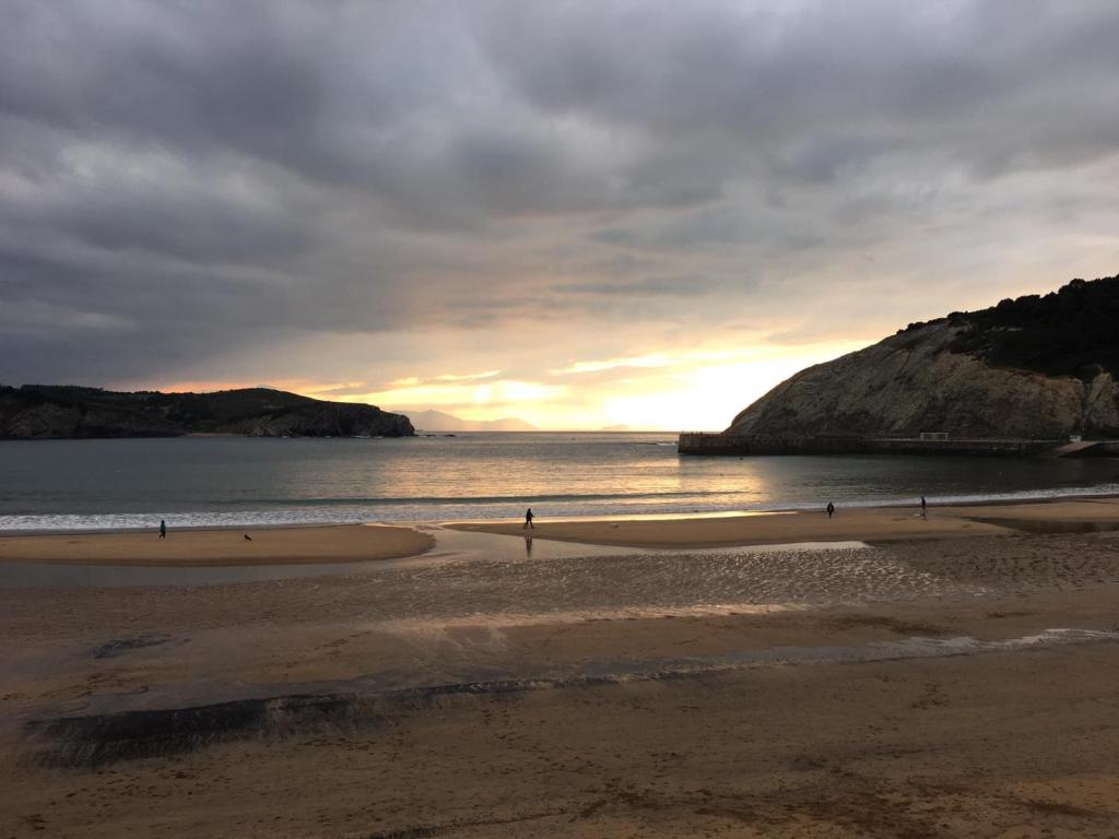 a group of people walking on the beach at sunset at Uribe-Biscay in Menaka