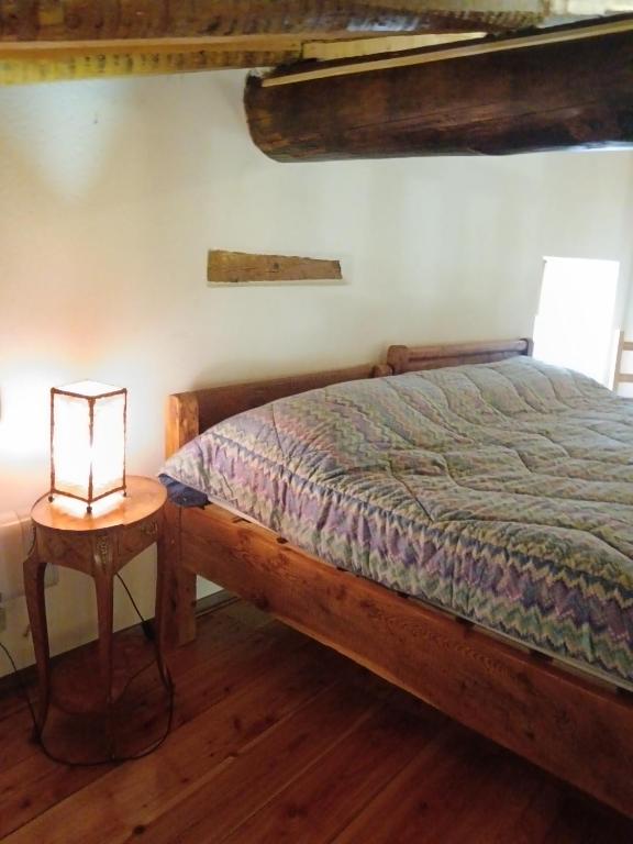 a bedroom with a bed and a lamp on a table at La casetta di Marmora in Marmora