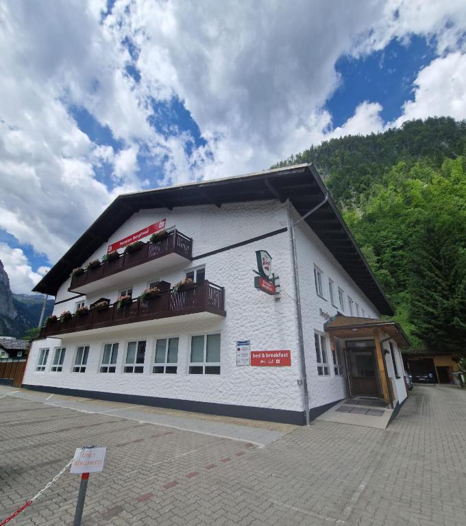 a white building with balconies on the side of it at Pension Bergfried in Hallstatt