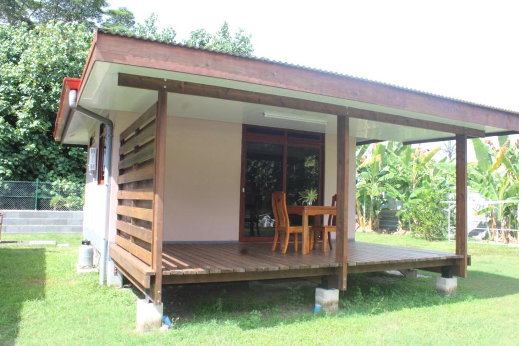 a tiny house with a porch and a table at Moorea Lodge Arii in Afareaitu