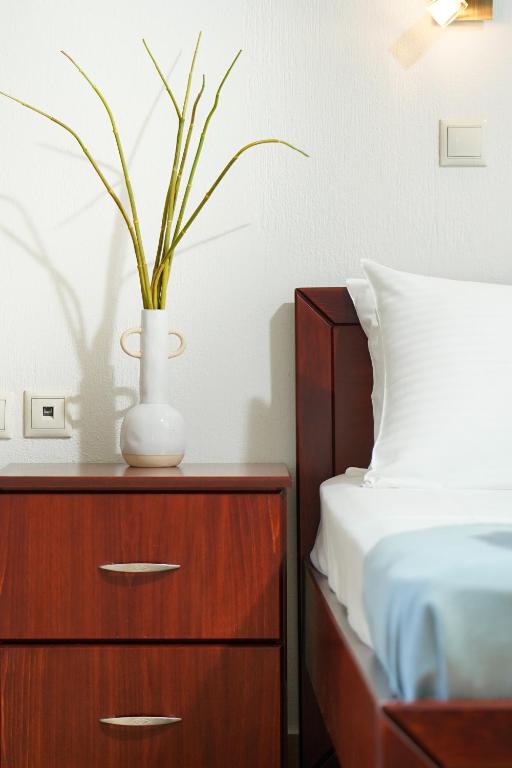 a bedroom with a bed and a dresser with a vase on it at Porto Nuovo Studio 2 in Limenas