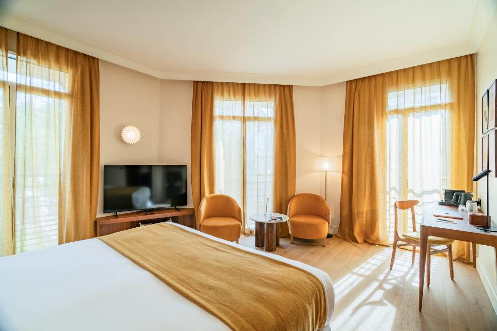 a hotel room with a bed and a television at Hôtel Lepoussin in Cannes