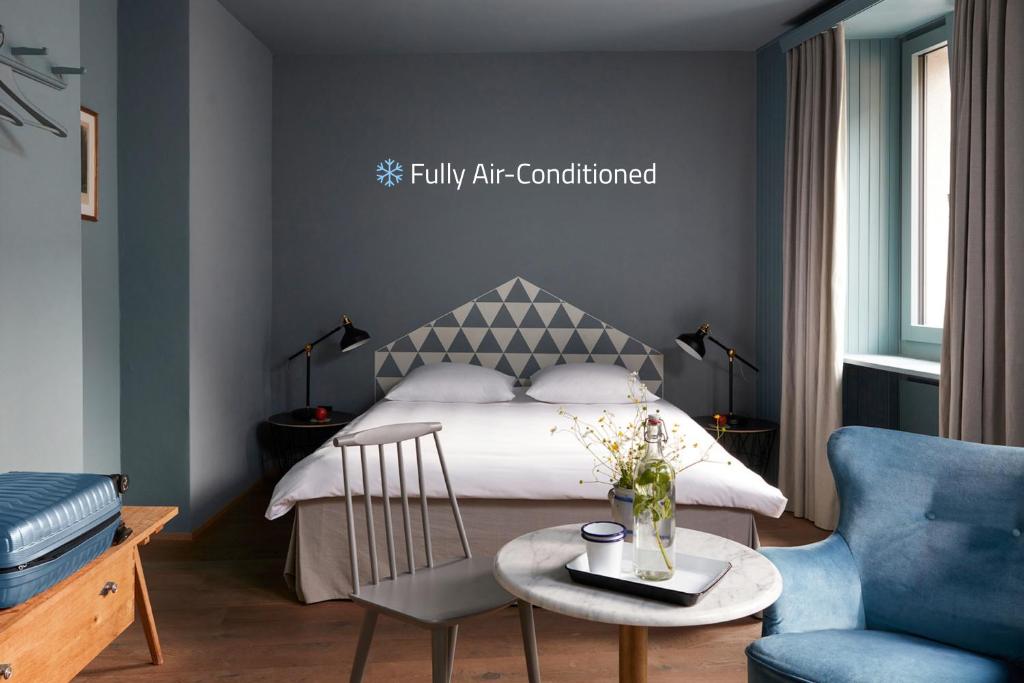 a bedroom with a bed and a table and a chair at Hotel De Londres in Brig