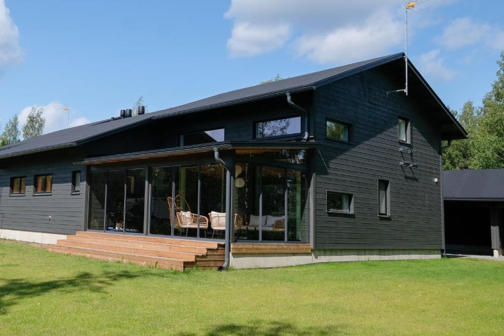 a black house with large glass doors and windows at Villa Arvonpiha A in Tahkovuori