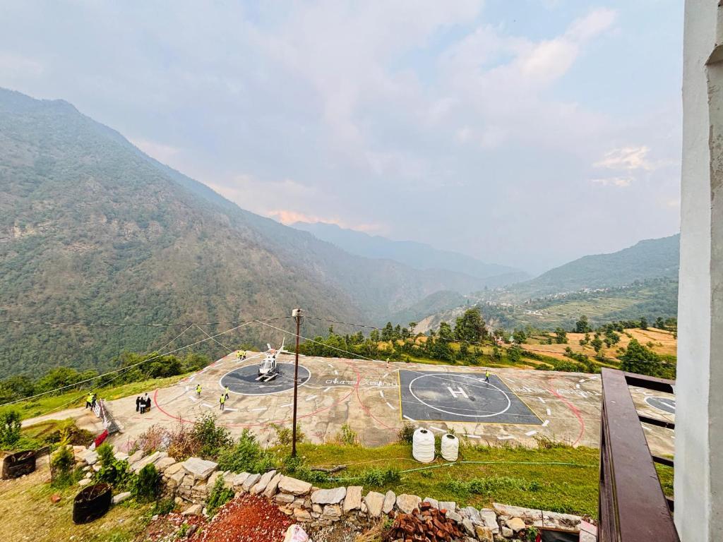 a view of a playground with mountains in the background at R K Hotel & HELY ROOMS in Phata