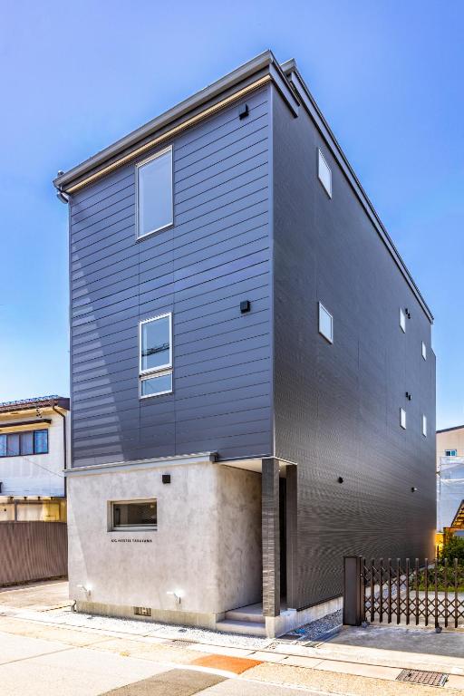 a house with a black wall on the side of it at UG HOSTEL Takayama in Takayama