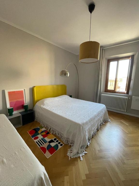 a bedroom with a white bed and a colorful rug at Appartamento ai piedi del Borgo in Certaldo