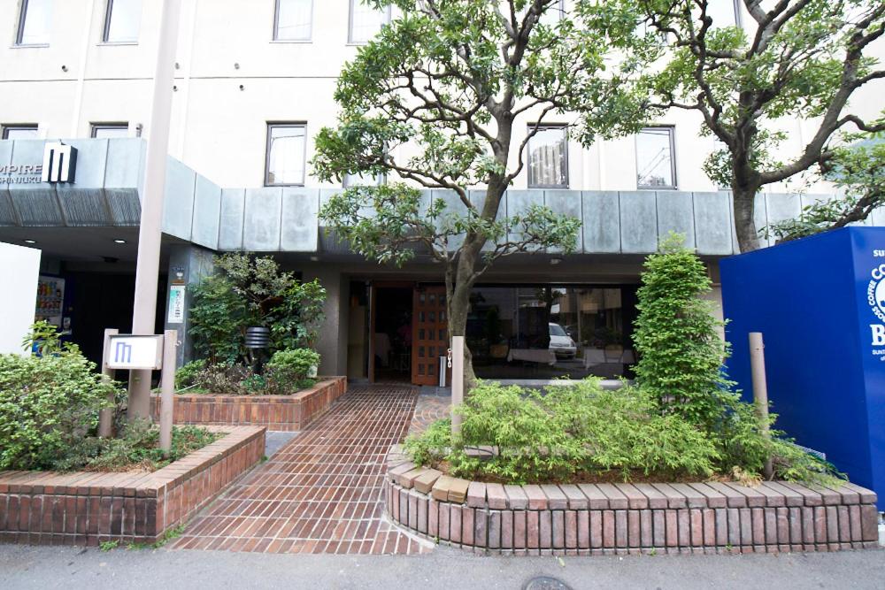 a brick building with a tree in front of it at Hotel Empire in Shinjuku in Tokyo