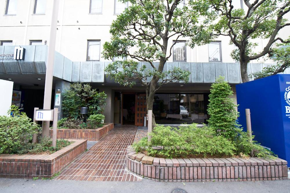 a building with a tree in front of it at Hotel Empire in Shinjuku in Tokyo