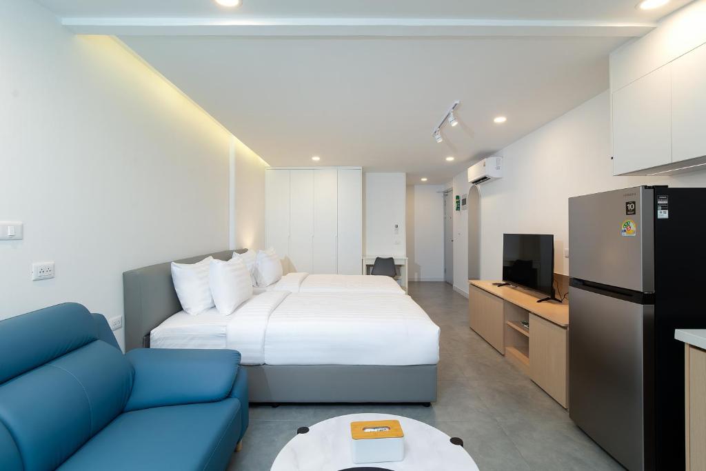 a hotel room with a bed and a blue couch at Mac's House in Bangkok