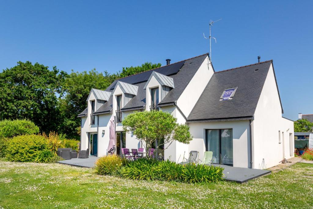 a white house with a black roof at Entre mer et rivière in Moëlan-sur-Mer