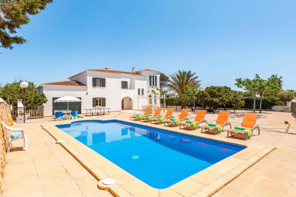 a villa with a swimming pool and chairs at Villa Xabec by Villa Plus in Cala en Blanes