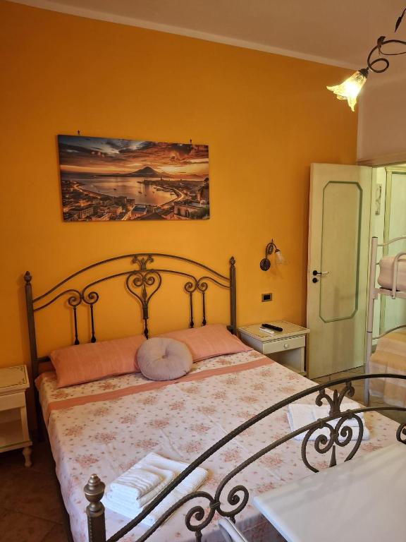 a bedroom with a bed in a room with yellow walls at Casa Vacanze Nantò 2 in Santa Maria di Castellabate