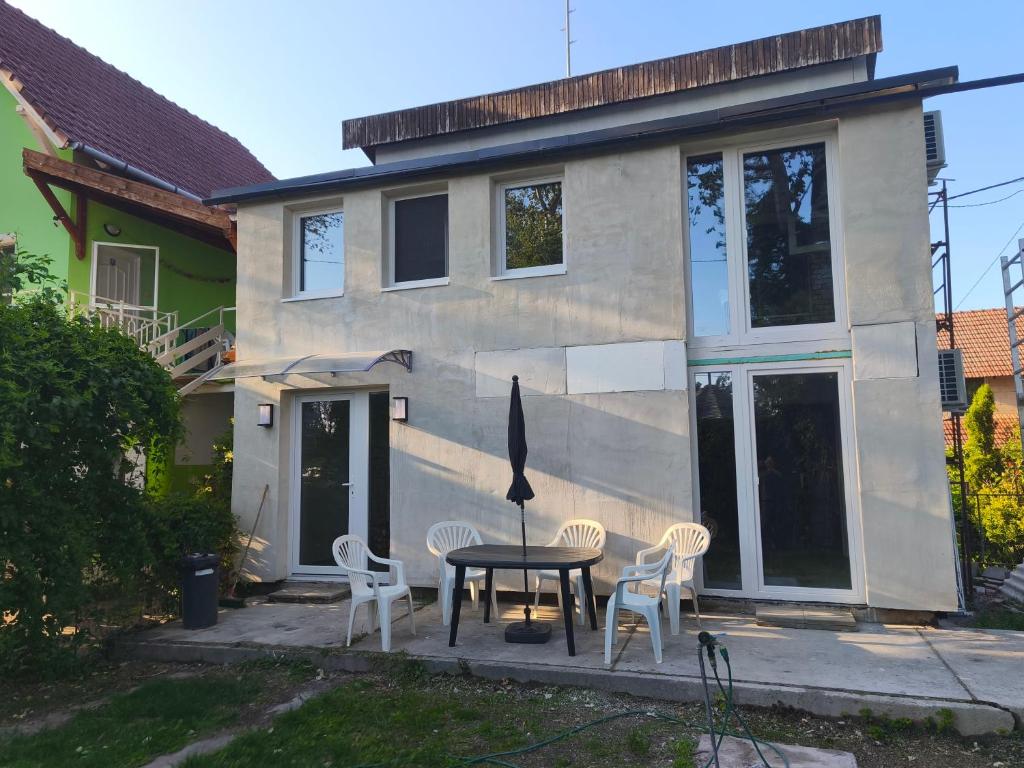 a table and chairs in front of a house at Sárga311 Üdülőház Szeged in Szeged
