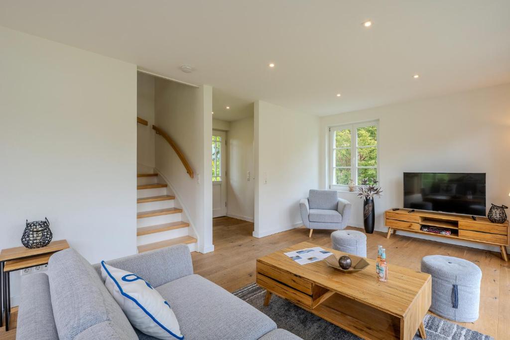 a living room with a couch and a tv at Traumgarten Haus Leichte Brise in Prerow