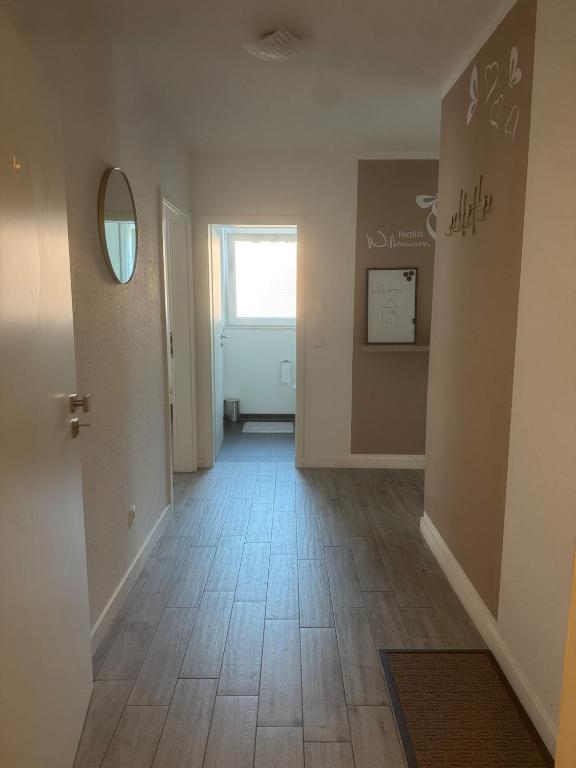 an empty hallway with a tile floor and a window at Lingen Stay 2 in Lingen