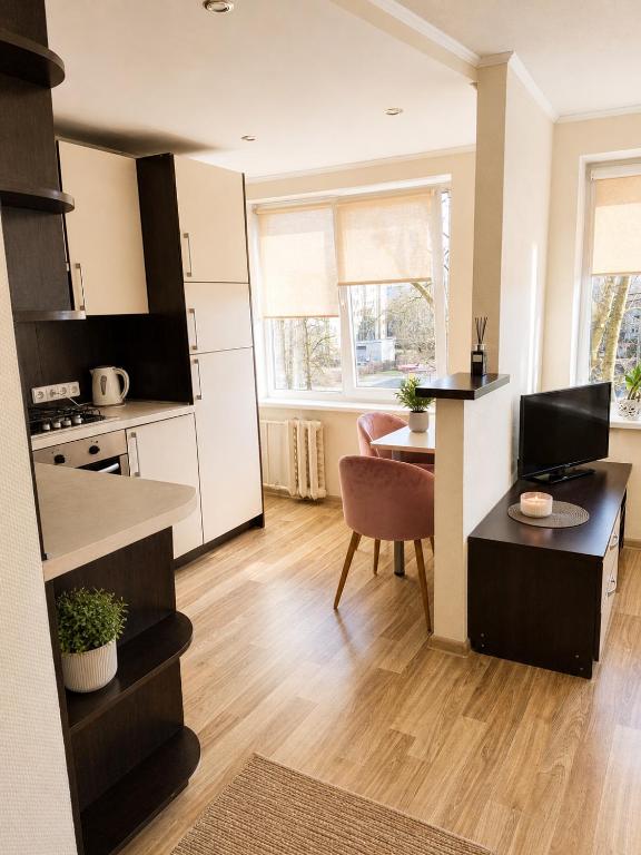 a kitchen and living room with a desk and a table at Nemunas in Panevėžys